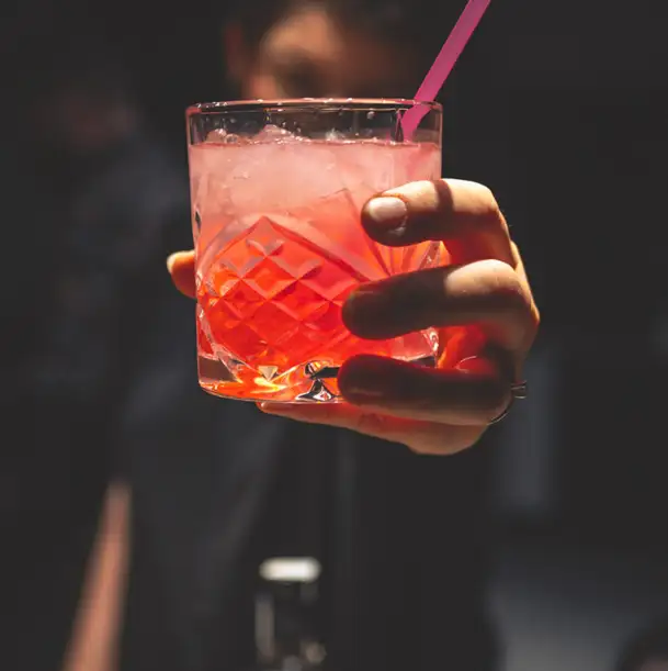 bartender serving ice cold red cocktail