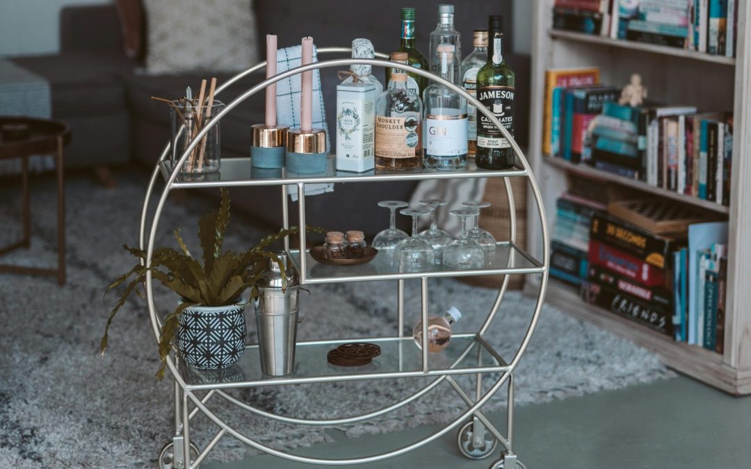 Elegant home bar cart with liquor, glassware, and cocktail essentials, styled in a modern living space.