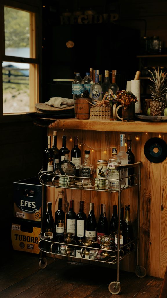 Rustic wine bar cart with vintage bottles and cozy wooden decor