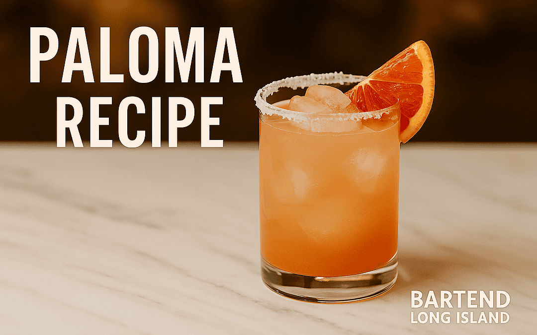 pink paloma cocktails in iced rocks glass and garnished withsalted rim, grapefruit wedge garnish, and ice cubes on a marble bar top with blurred warm background. Text overlay reads Paloma Recipe with Bartend Long Island logo