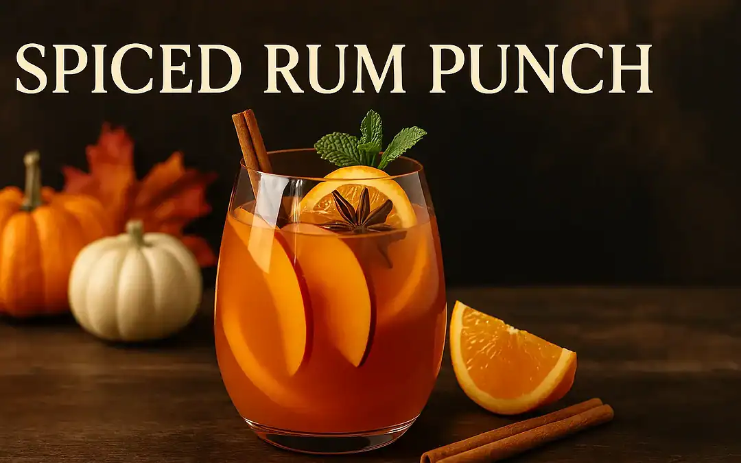 Spiced Rum Punch cocktail with orange slices, cinnamon stick, and star anise served in a glass on a rustic autumn table with pumpkins and leaves