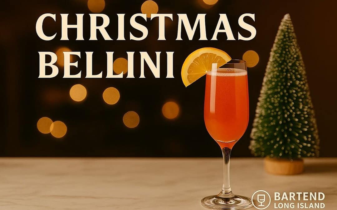 Christmas Bellini cocktail in a champagne flute with a red-orange hue and orange slice garnish, placed on marble with a mini Christmas tree and warm golden holiday lights in the background.