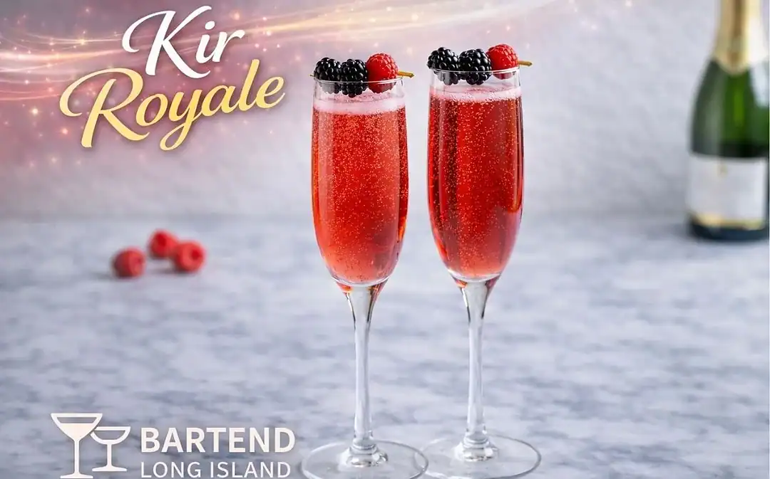 two kir royale champagne flutes garnished with berries on granite with champagne in back