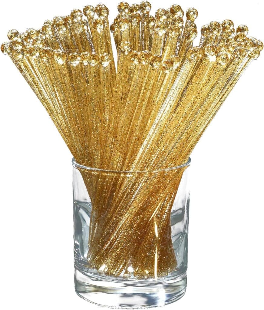 Gold ball top cocktail stirrers displayed in a clear glass